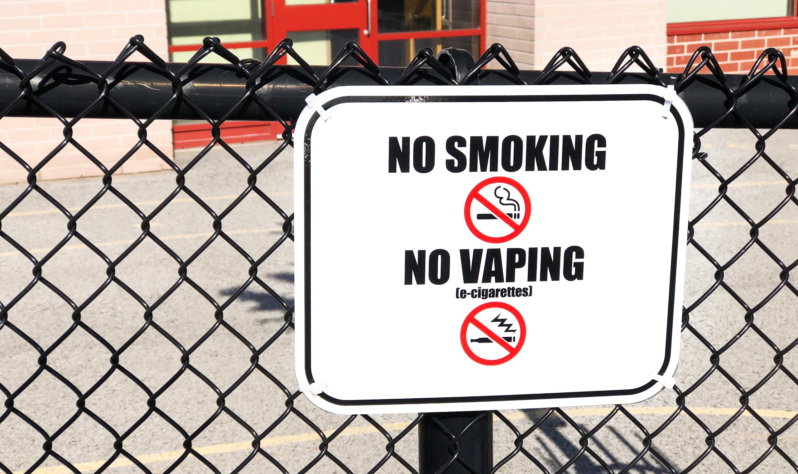 A no smoking, no vaping sign seen on a fence.