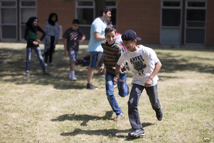 Children seen running with a soccer ball.