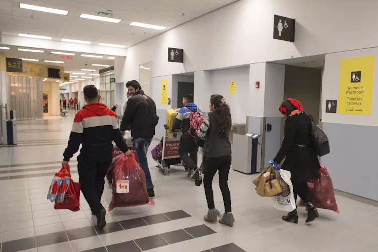 The backs of people seen at an airport.
