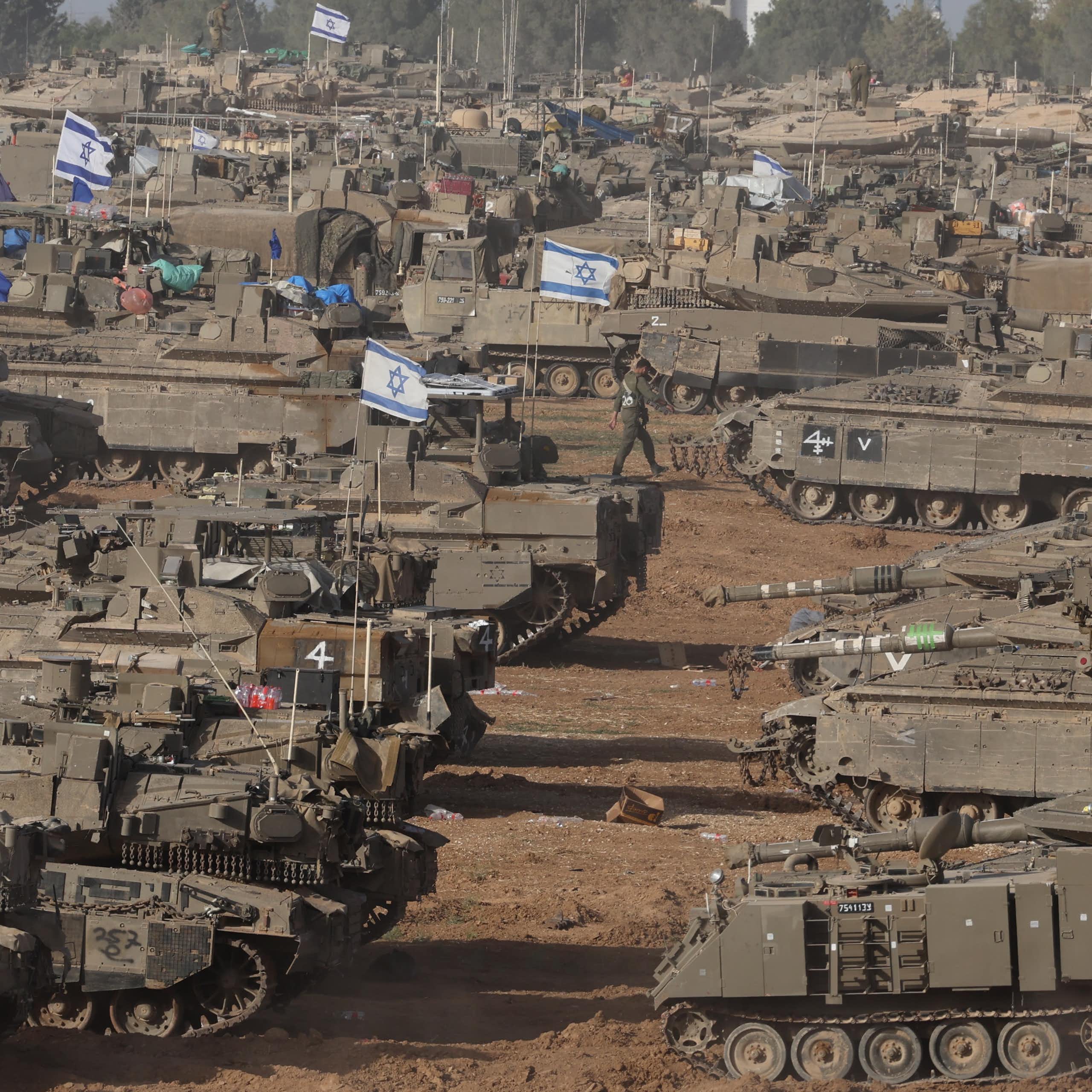 Israeli tanks gathered on a sandy patch of land.