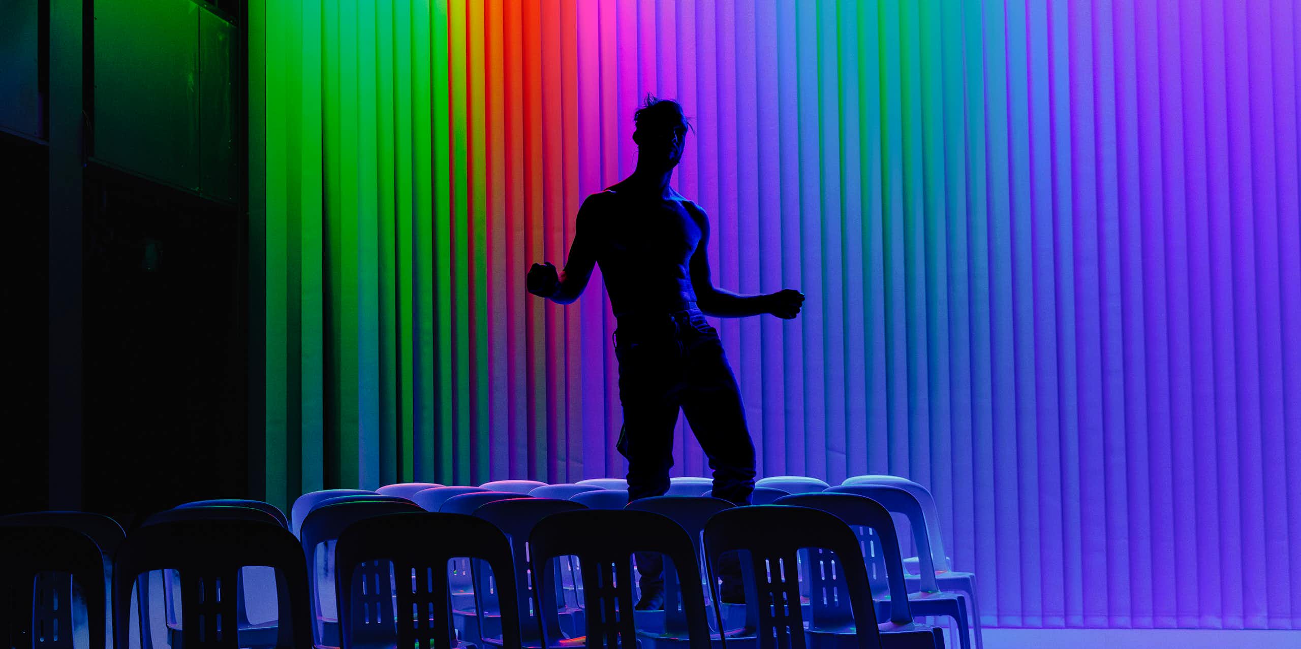 The silhouette of a man against a rainbow backdrop