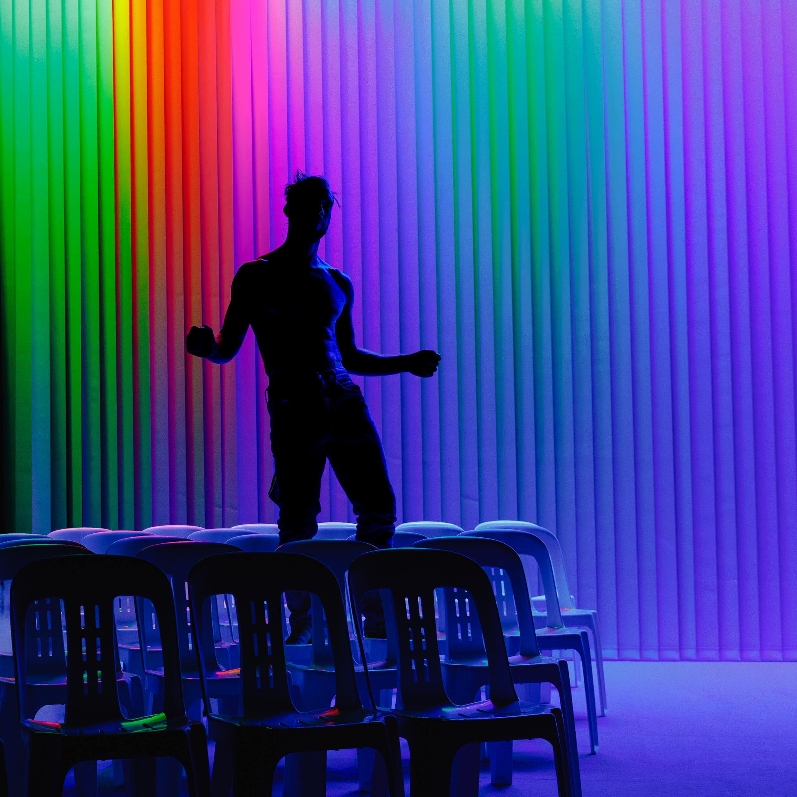 The silhouette of a man against a rainbow backdrop