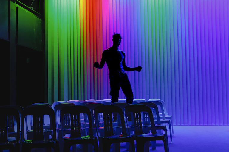 The silhouette of a man against a rainbow backdrop