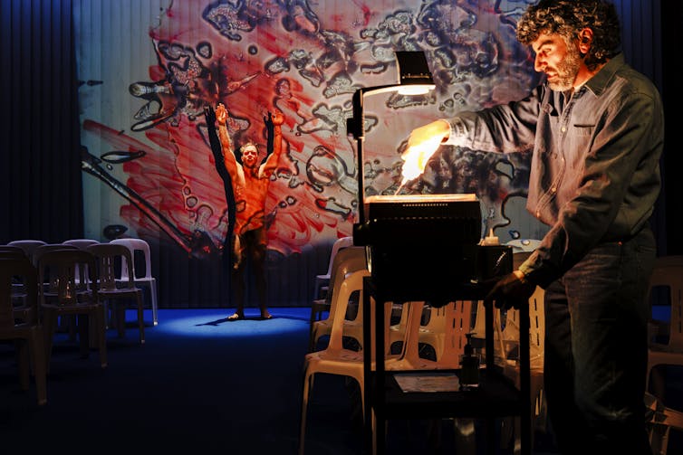 A man scribbles on an overhead projector.