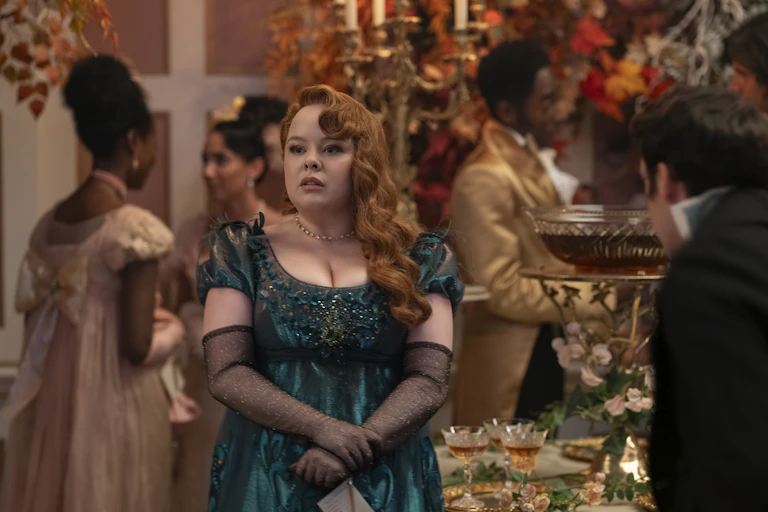Woman in Regency-era dress stands in ornate room