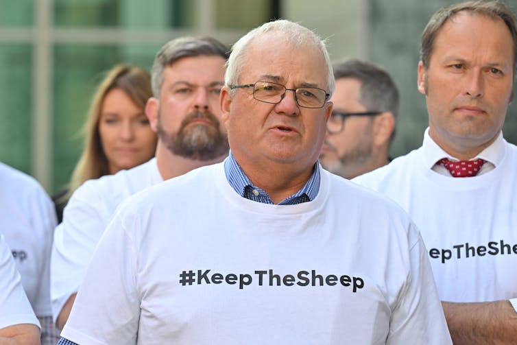 WA Farmers President John Hassell speaks at a press conference while wearing a shirt that reads: hashtag keepthesheep