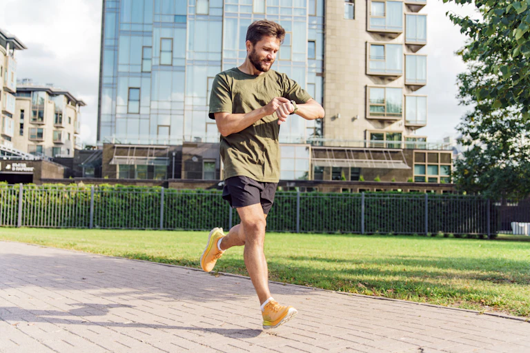 A man checks his smart watch while out on a run.