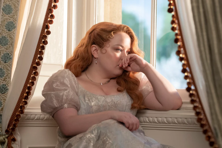 A young woman of the Regency period sitting pensively by a window.