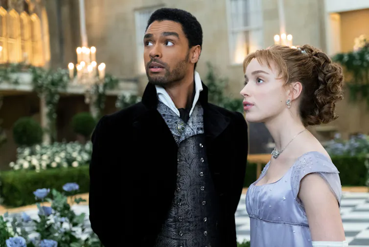 A young regency couple from Bridgerton, the man is black and the woman is white.