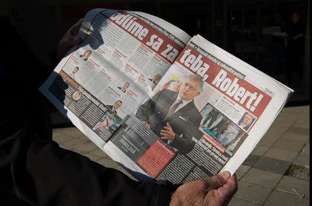 A man holds a newspaper