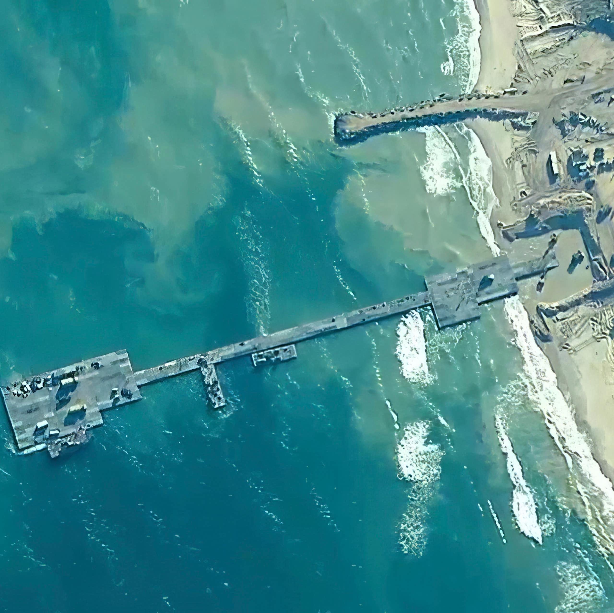 An overhead image shows a floating platform connected by a floating roadway to a beach.
