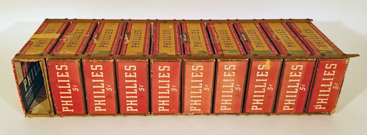 A group of cigar boxes are held together with wooden rods and metal screws.
