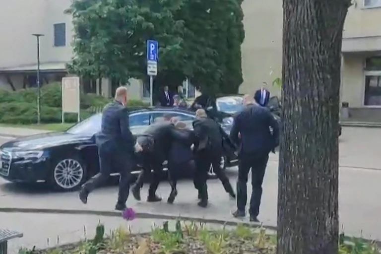 Un homme, de dos, est entraîné vers une voiture noire.