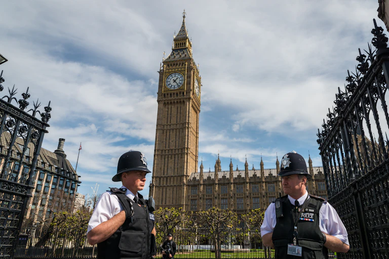 Two London police officers standing in front of Westminster palace