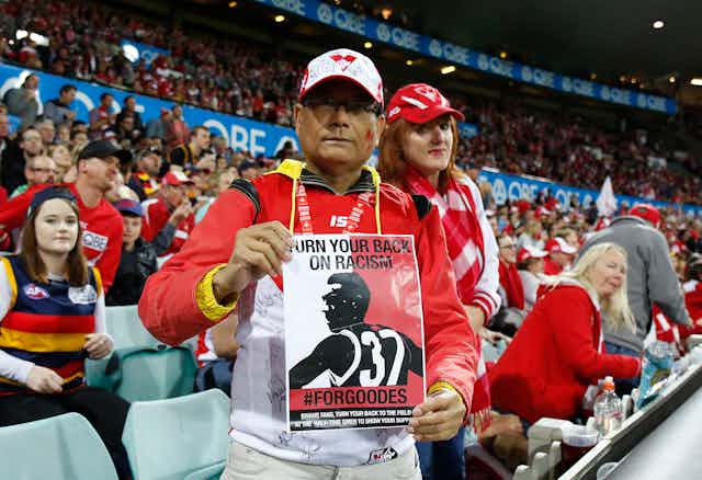 A Sydney Swans fan holds a leaflet in support of Adam Goodes in 2015