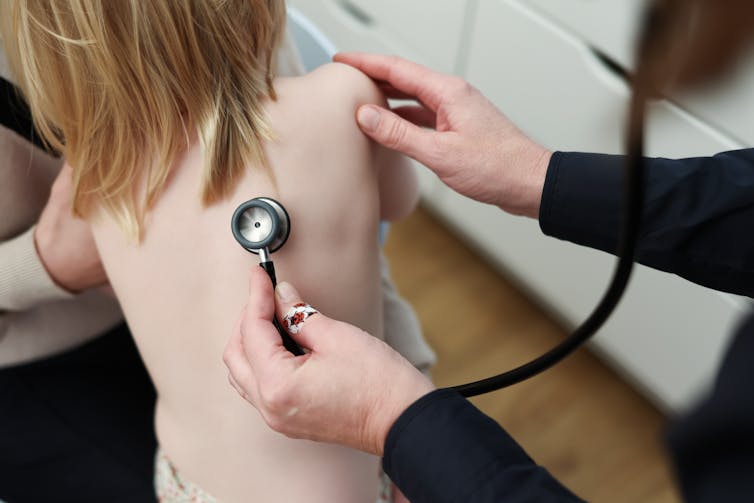 A young child being examined with a stethoscope.