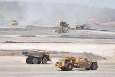 Trucks drive across the construction site of Western Sydney airport