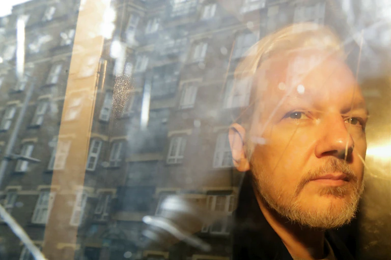 A man lit by orange light sitting behind a car window