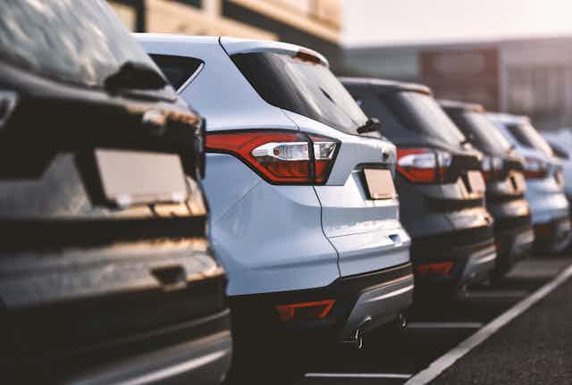 Closeup of cars parked in a row, showing their backsides