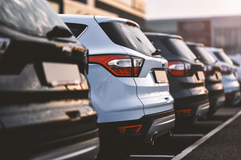 Closeup of cars parked in a row, showing their backsides