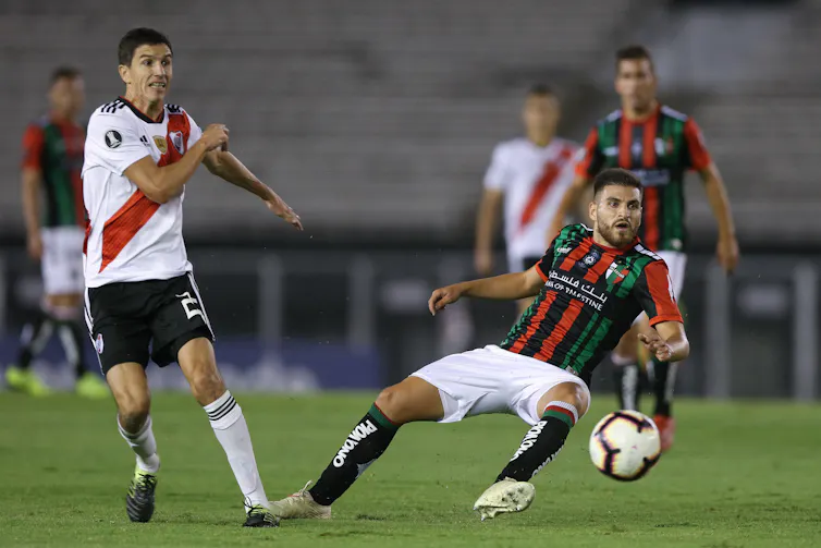Two football players competing for the ball during a match.