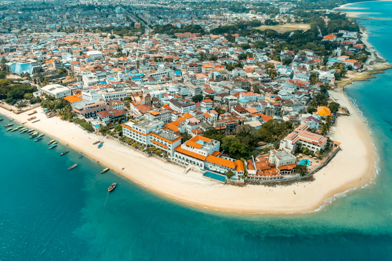 An aerial view of the sea and a beach surrounding an urban settlement