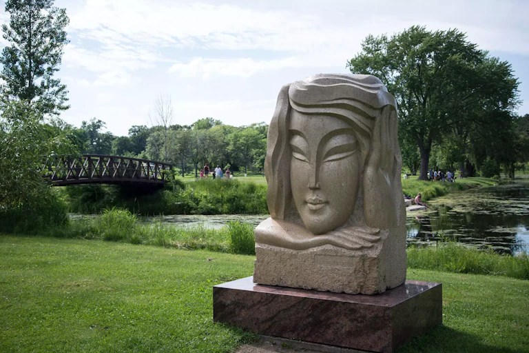 A large stone block, carved with a young female face