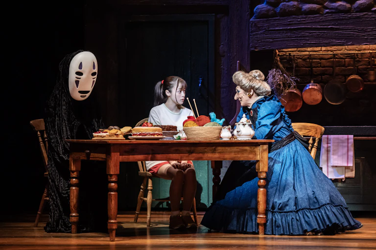 No Face, Chihiro and Yubaba at a table.