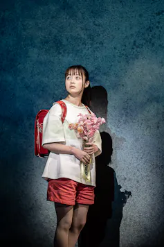 Girl with backpack and flowers.