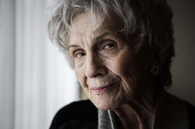 An old intelligent-looking woman looking wryly at the camera.