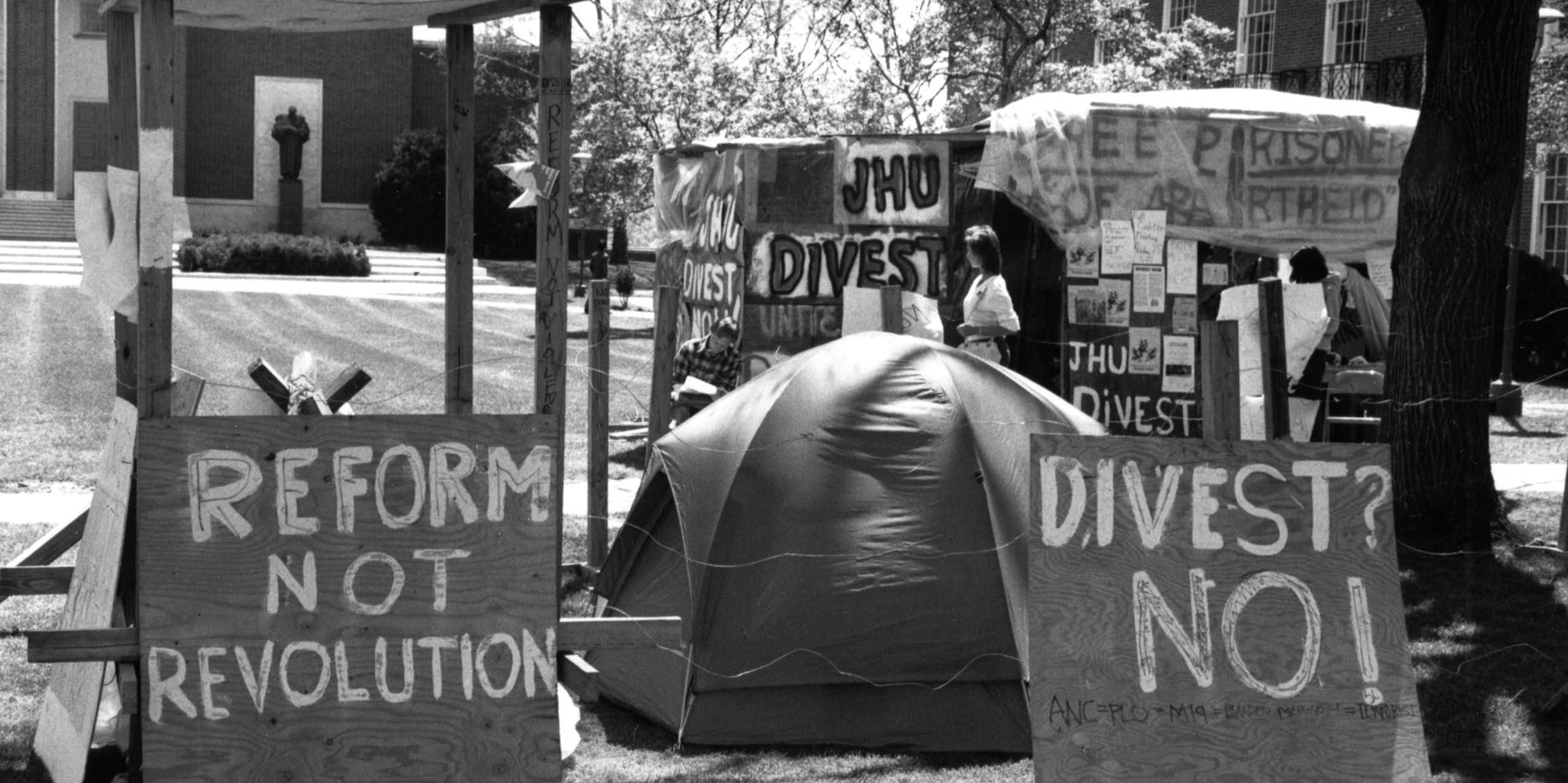 Tents and signs on a university lawn.