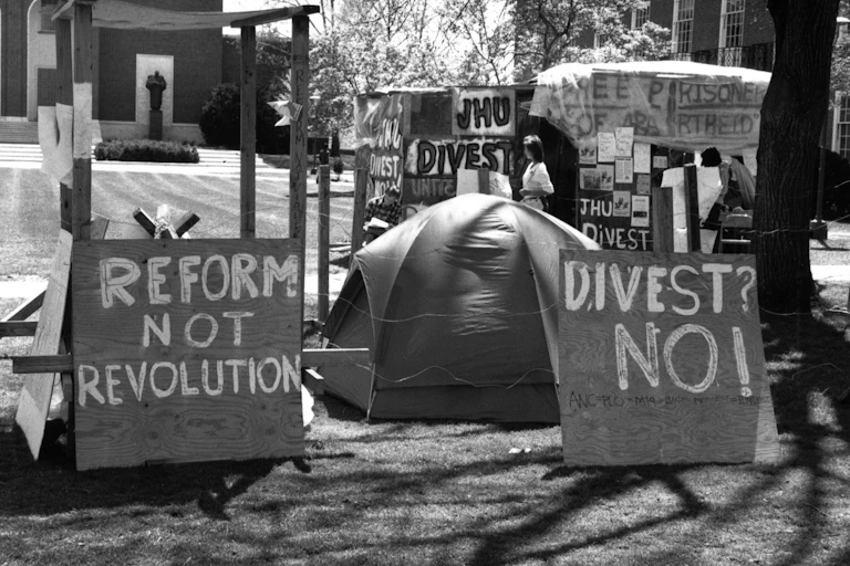 Tents and signs on a university lawn.