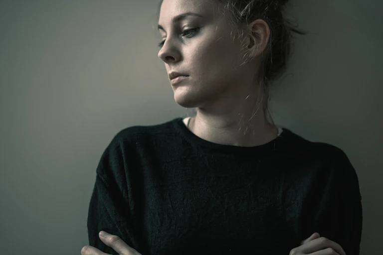 Woman looks sad, arms crossed