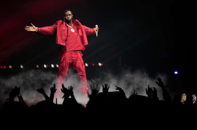 A man in a red suit on stage.