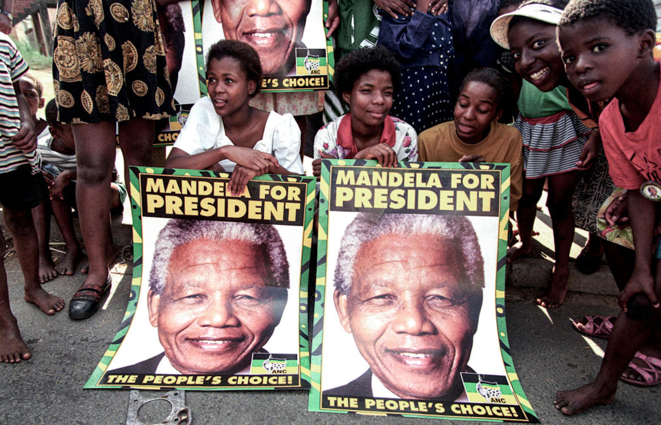 Young people pose with posters saying 'Mandela for president'. 