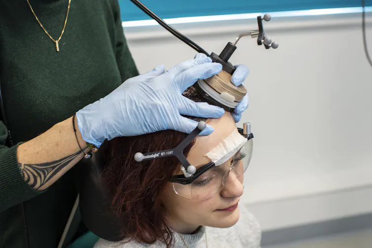 Jeune femme recevant un traitement par ultrasons transcrâniens