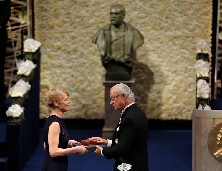 A woman being presented with an award on stage.