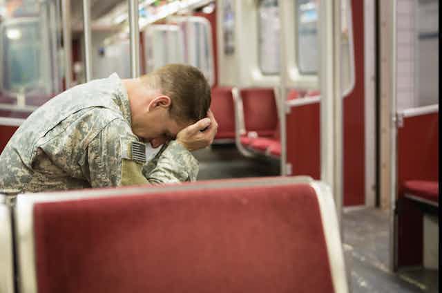 Soldier sitting on the train with head in hands