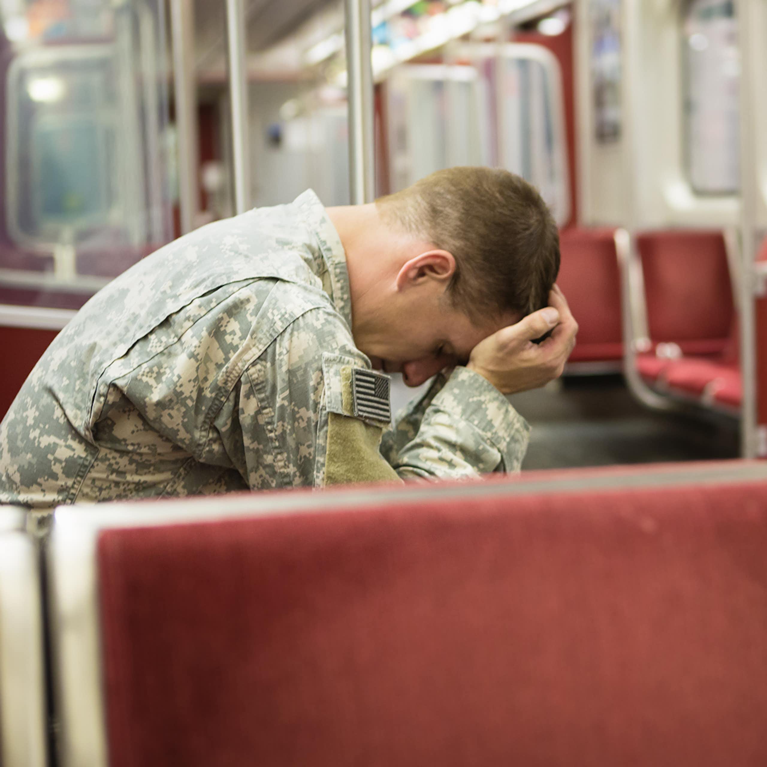 Soldier sitting on the train with head in hands