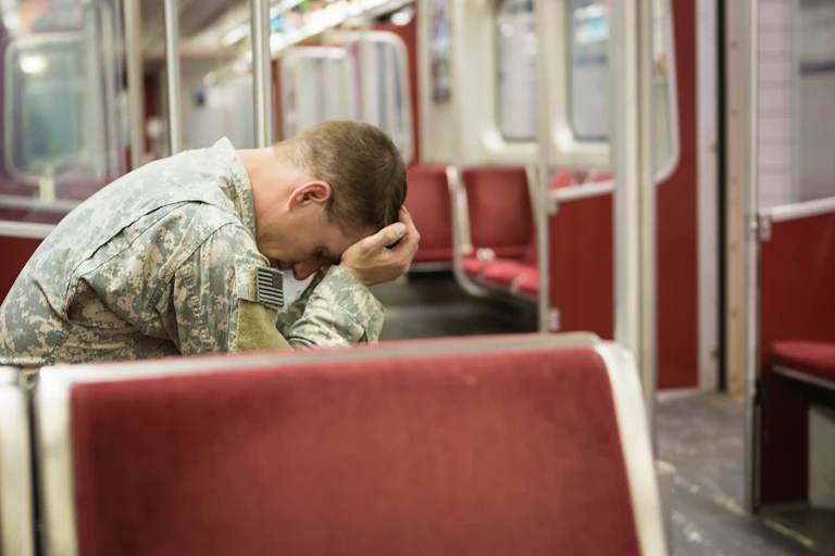 Soldier sitting on the train with head in hands