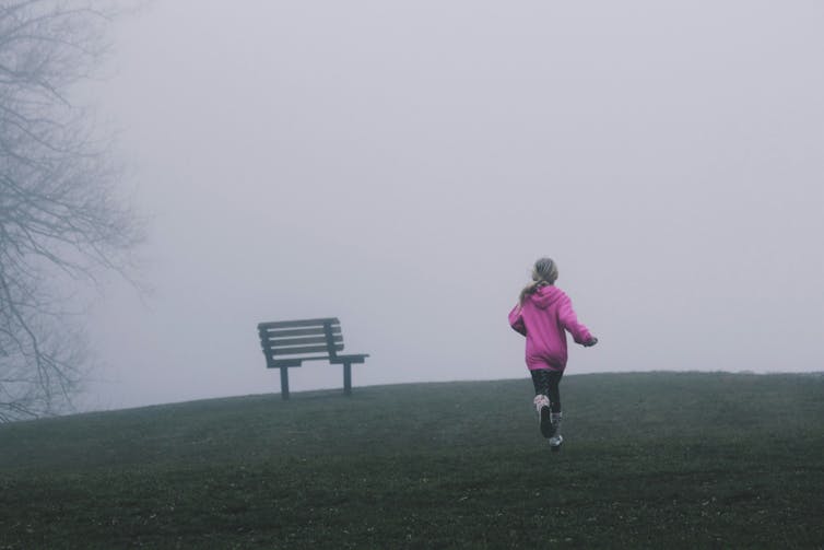 Girl runs up a hill in winter