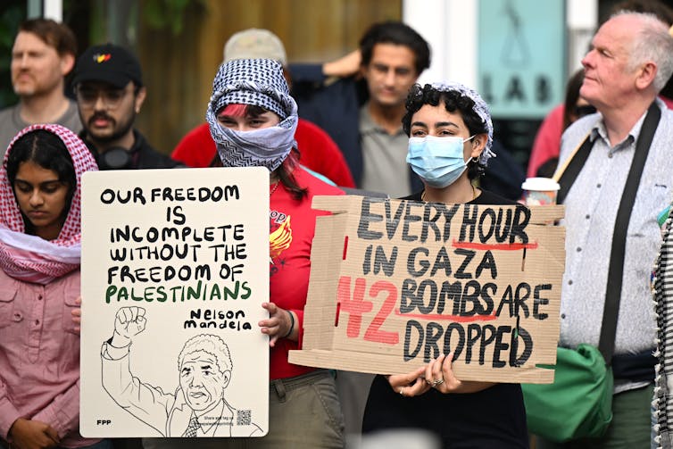 Protesters in face masks with placards.