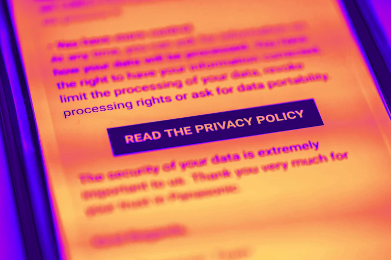 A brightly coloured photo of a smartphone screen displaying a button asking to a read a privacy policy.