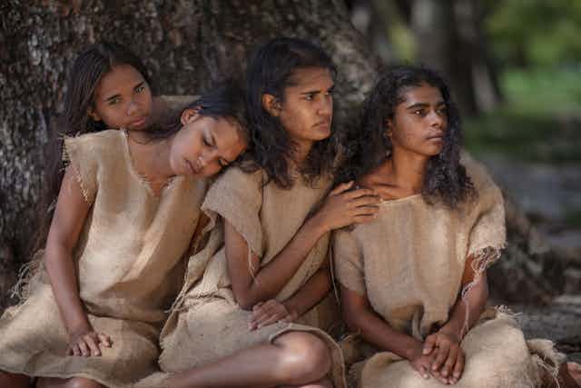 Four young Aboriginal women in dresses made from hessian