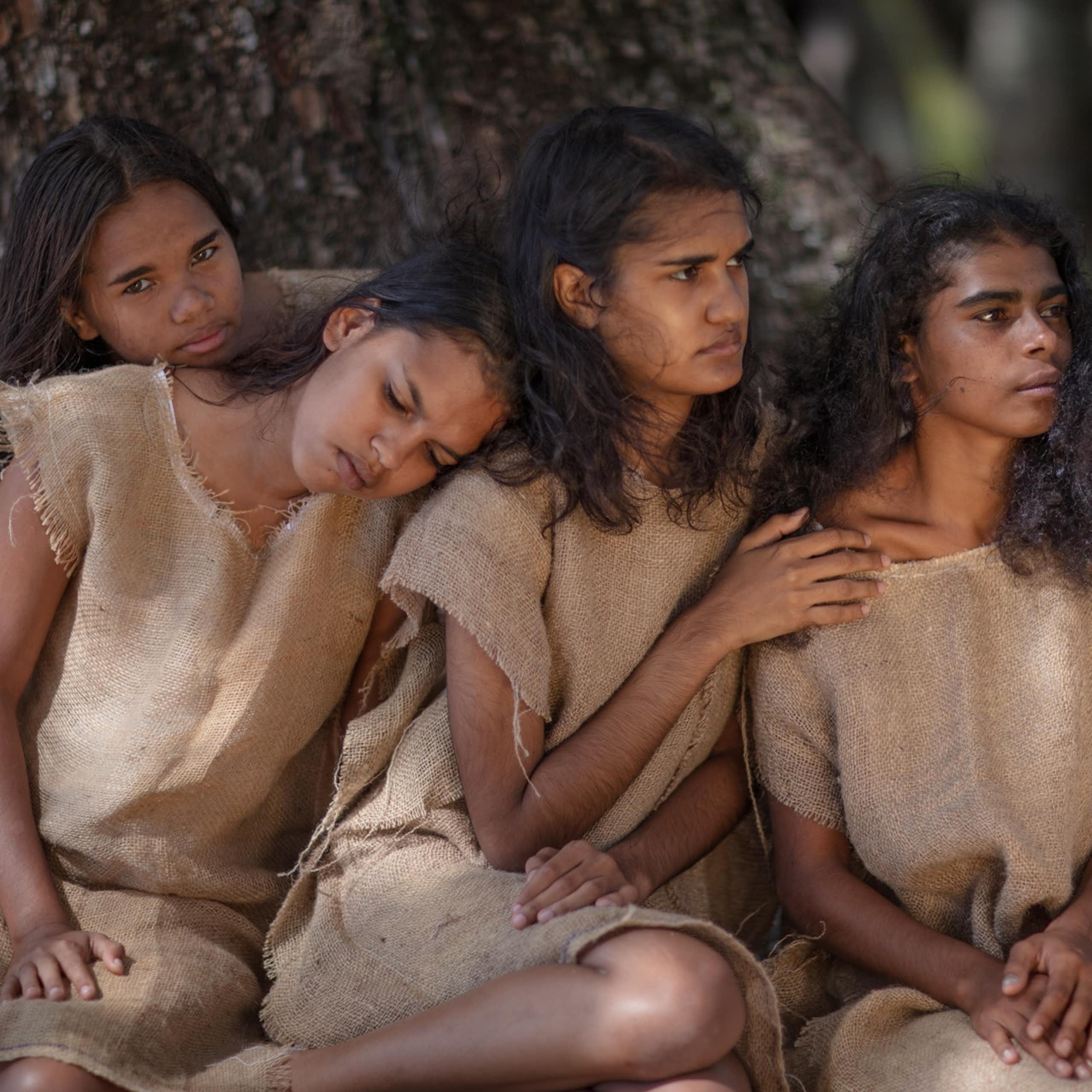 Four young Aboriginal women in dresses made from hessian