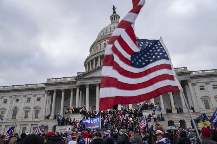 A crowd streams up the steps of the US Capitol.