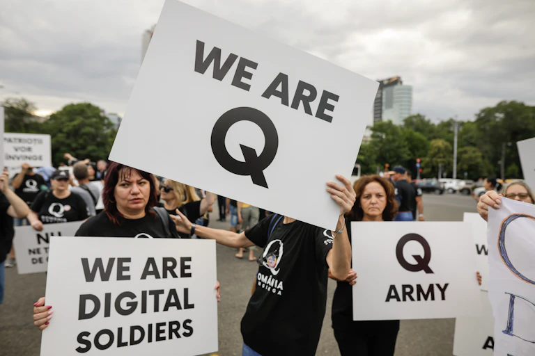 Des gens se revendiquent de QAnon en brandissant des affiches