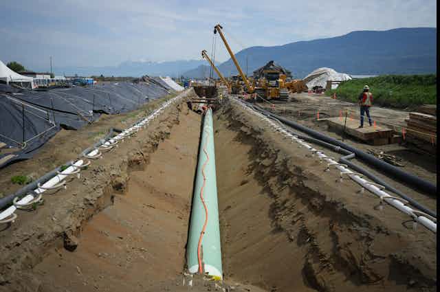 Workers lay a pipeline.