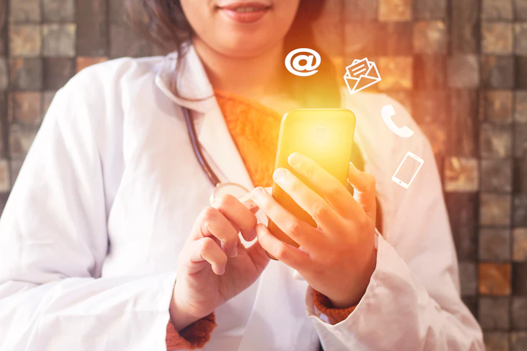 Cropped image of woman in a white coat holding a phone