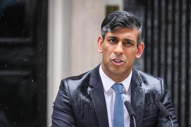 Rishi Sunak giving a speech in rain.